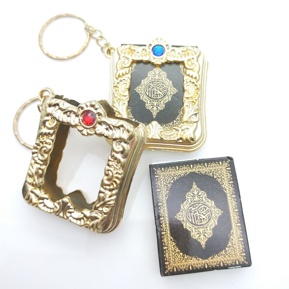 Golden Quran keychain pendant with intricate hanging ring design, compact and decorative Islamic accessory.