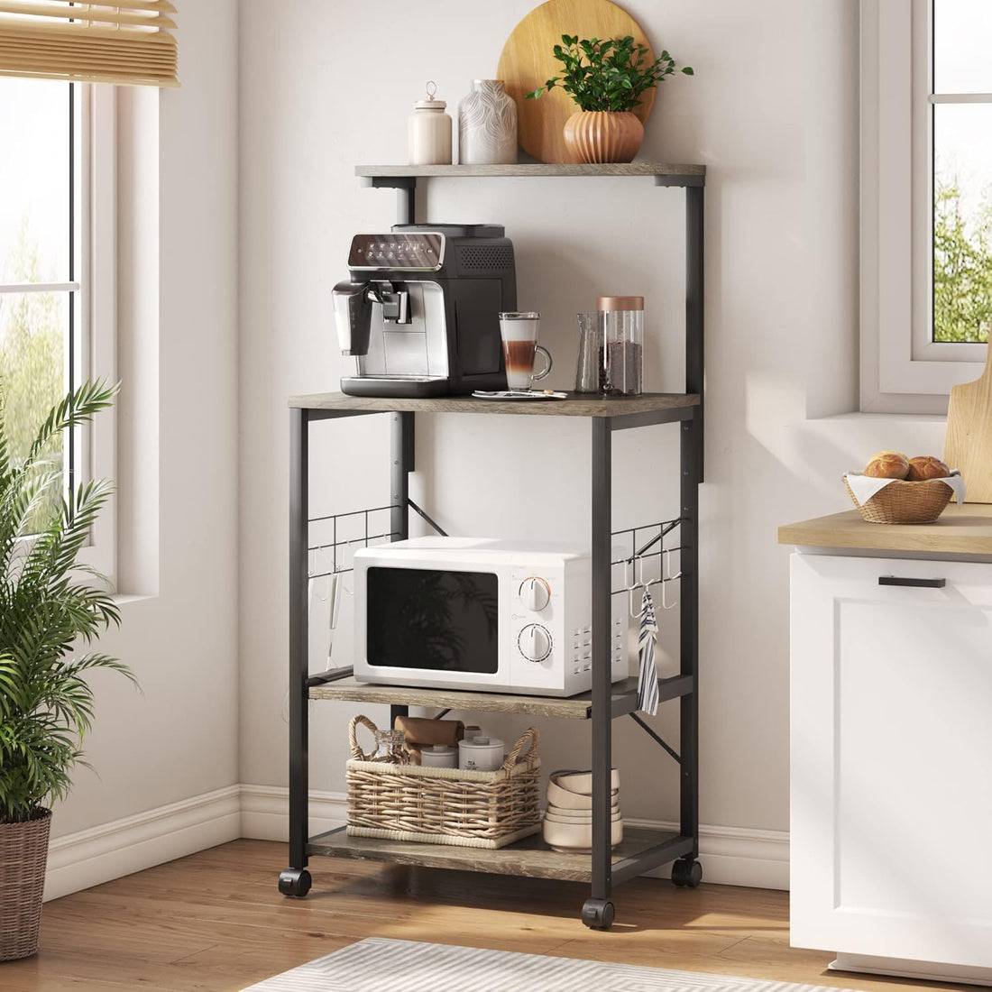 RoyalSavings kitchen bakers rack with wheels, adjustable feet, side hooks, and multiple shelves for microwave and utility storage.